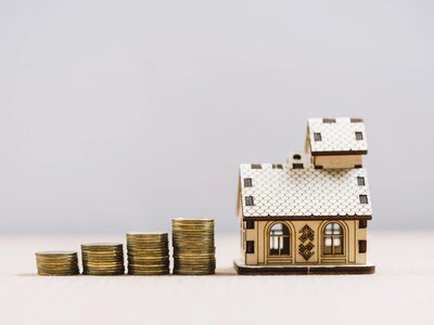 piles-of-coins-near-small-house