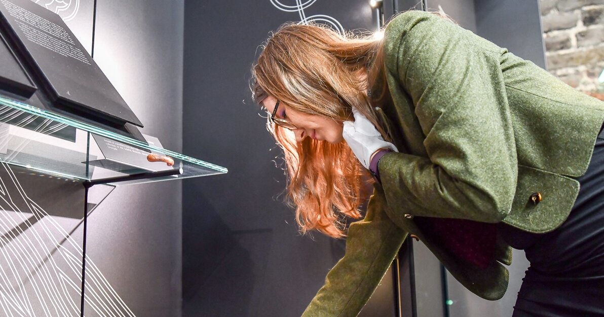 Julia Haldyi umieszcza krzyżyk w gablocie na wystawie stałej w Muzeum Bursztynu. 