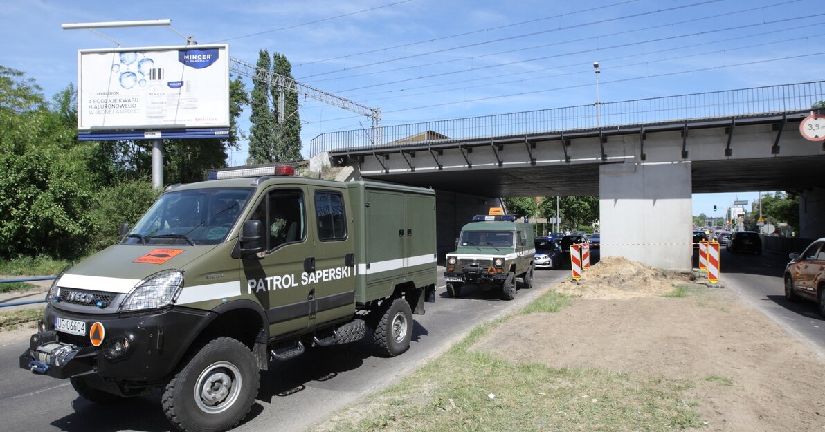 Na zdjęciu, po lewej stronie samochody patrolu saperskiego, jadące w kolumnie. 