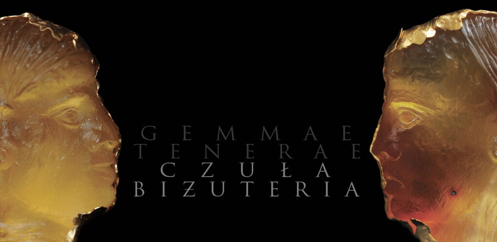 Grafika. Na czarnym tle z obu stron dwie twarze kobiece z bursztynu zwrócone twarzami ku sobie. W środku napis Czuła biżuteria i niżej Gemmae tenerae. 